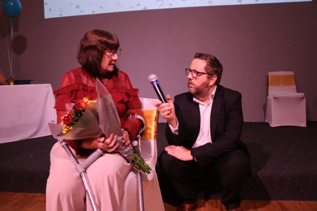 Ben McGrail speaking it Overall Garden Competition winner, Michelle.